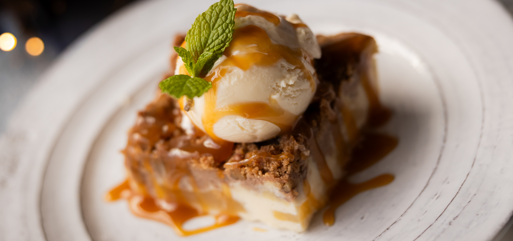 Old-Fashioned Apple Cobbler with Vanilla Ice Cream and a mint leave on top.